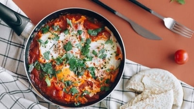 Shakshuka: Sauté diced onions, bell peppers, and garlic in a skillet. Add canned tomatoes, spices like cumin and paprika, and simmer until thickened. Make small wells in the sauce and crack eggs into them. Cover and cook until the eggs are done to your liking. Serve with crusty bread for a delicious and flavorful breakfast. (Pexels) Shakshuka: Sauté diced onions, bell peppers, and garlic in a skillet. Add canned tomatoes, spices like cumin and paprika, and simmer until thickened. Make small wells in the sauce and crack eggs into them. Cover and cook until the eggs are done to your liking. Serve with crusty bread for a delicious and flavorful breakfast. (Pexels)