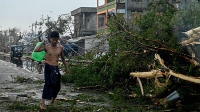 A man walks past a broken tree in Sittwe, in Myanmar's Rakhine state, on Monday. (AFP) A man walks past a broken tree in Sittwe, in Myanmar's Rakhine state, on Monday. (AFP)