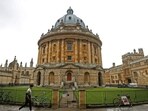 A man walks in front of the buildings of Oxford University. A man walks in front of the buildings of Oxford University.