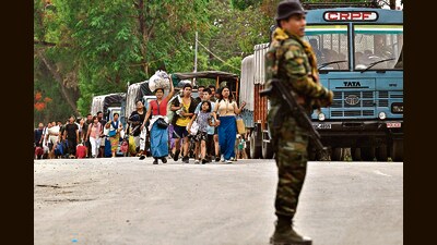 People arrive to board a paramilitary truck at a transit point after being evacuated from Churachandpur, near Imphal, on May 9. (AFP) People arrive to board a paramilitary truck at a transit point after being evacuated from Churachandpur, near Imphal, on May 9. (AFP)