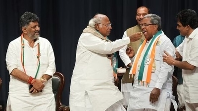 Congress president Mallikarjun Kharge offers sweets to Siddaramaiah during celebrations after the party's win in Karnataka Assembly elections, as state unit chief DK Shivakumar looks on. (PTI)