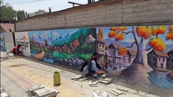 Artists painting city walls as a part of beautification project ahead of the G20 event at Ghanta Ghar Lal Chowk, in Srinagar. (ANI)