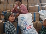 Workers sort through food at a damaged UN World Food Programme warehouse in Sittwe on May 17, 2023, in the aftermath of Cyclone Mocha's landfall. 