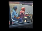 Bengaluru woman working on laptop while riding pillion.