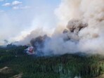 Smoke rises above the southeast perimeter of the Paskwa fire (HWF030) as it burns near Fox Lake, Alberta, Canada May 16. (via REUTERS)