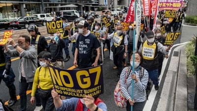 Several anti-G7 protesters march down a street in Hiroshima on May 19, 2023, as world leaders meet on the first day of the G7 Summit Leaders' Meeting nearby. (AFP)