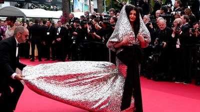 Aishwarya Rai needed help with her larger-than-life gown as she walked down the red carpet with an assistant. (REUTERS) 