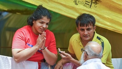 Wrestler Sakshi Malik greets a supporter during the ongoing protest against the alleged sexual harassment of women wrestlers by Wrestling Federation of India (WFI) chief Brij Bhushan Sharan Singh, in New Delhi on Thursday. (ANI) Wrestler Sakshi Malik greets a supporter during the ongoing protest against the alleged sexual harassment of women wrestlers by Wrestling Federation of India (WFI) chief Brij Bhushan Sharan Singh, in New Delhi on Thursday. (ANI)