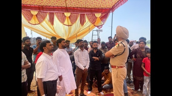 DSP Gurmukh Singh pacifying Dhanas residents who staged a protest over ‘police inaction’. (HT Photo)