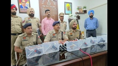 Mohali police officials with the seized weapons in Mohali on Saturday. (HT Photo)