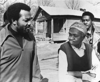 Former football great Jim Brown, left, President of the Black Economic Union, confers with Mrs. Anne Faulkner, 74, in her poor neighborhood at Holly Springs, Miss., Feb. 11, 1970. Brown led about 25 black athletes for the firsthand look at conditions his BEU hopes to improve. In background is Leroy Kelly of the Cleveland Browns. (AP) Former football great Jim Brown, left, President of the Black Economic Union, confers with Mrs. Anne Faulkner, 74, in her poor neighborhood at Holly Springs, Miss., Feb. 11, 1970. Brown led about 25 black athletes for the firsthand look at conditions his BEU hopes to improve. In background is Leroy Kelly of the Cleveland Browns. (AP)