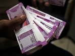 A cashier displays the new 2000 Indian rupee banknotes inside a bank in Jammu.