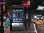 A poster at a bus shelter shows the national debt in Washington, DC, on May 21, 2023. A poster at a bus shelter shows the national debt in Washington, DC, on May 21, 2023.