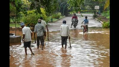 People wade through a waterlogged road after a rain shower in Bangalore (AFP) People wade through a waterlogged road after a rain shower in Bangalore (AFP)