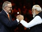 Prime Minister Narendra Modi (R) and Australia's Prime Minister Anthony Albanese gesture during an event with members of the local Indian community at the Qudos Arena in Sydney 