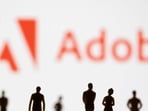 FILE PHOTO: Figurines are seen in front of displayed Adobe logo in this illustration taken June 13, 2022. REUTERS/Dado Ruvic/Illustration/File Photo