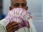 A man holds <span class='webrupee'>₹</span>2000 currency notes at a bank in New Delhi, Tuesday, May 23, 2023. A man holds <span class='webrupee'>₹</span>2000 currency notes at a bank in New Delhi, Tuesday, May 23, 2023.
