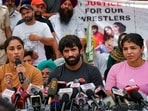 Wrestlers Sakshi Malik, Vinesh Phogat and Bajrang Punia speak with the media during their protest at Jantar Mantar in New Delhi, Monday.
