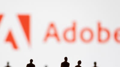 FILE PHOTO: Figurines are seen in front of displayed Adobe logo in this illustration taken June 13, 2022. REUTERS/Dado Ruvic/Illustration/File Photo