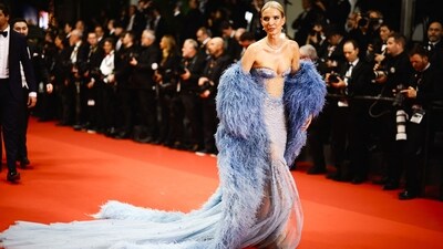 Leonie Hanne posed for the photographers in a blue dress and matching cape. (REUTERS) 