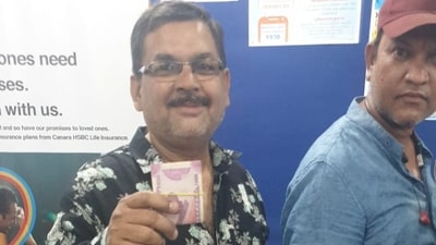 A businessman Alok Vijaywargiya showing <span class='webrupee'>₹</span>2000 notes while standing in a queue to deposit money in his bank account. (HT Photo) A businessman Alok Vijaywargiya showing <span class='webrupee'>₹</span>2000 notes while standing in a queue to deposit money in his bank account. (HT Photo)