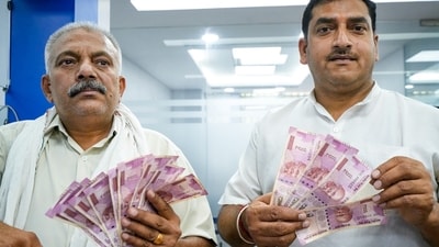 People show <span class='webrupee'>₹</span>2000 currency notes as they wait to deposit at a bank in New Delhi, Tuesday, May 23, 2023. (PTI) People show <span class='webrupee'>₹</span>2000 currency notes as they wait to deposit at a bank in New Delhi, Tuesday, May 23, 2023. (PTI)