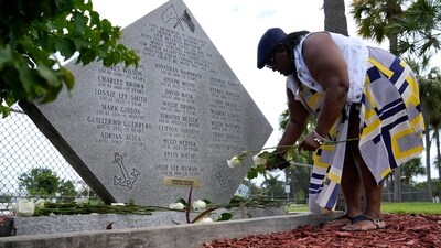 Fredricka Woods leaves white roses at a memorial on Workers Memorial Day to remember workers who have died or suffered illnesses or injuries on the job, Tuesday, April 25, 2023, at PortMiami in Miami. (AP Photo/Lynne Sladky) (AP) Fredricka Woods leaves white roses at a memorial on Workers Memorial Day to remember workers who have died or suffered illnesses or injuries on the job, Tuesday, April 25, 2023, at PortMiami in Miami. (AP Photo/Lynne Sladky) (AP)