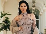 Sunny Leone poses in a printed dress and tan jacket at the Cannes Film Festival. Sunny Leone poses in a printed dress and tan jacket at the Cannes Film Festival.