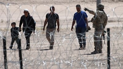 Migrants wait for U.S. authorities, between a barbed-wire barrier and the border fence at the US-Mexico border (AP) Migrants wait for U.S. authorities, between a barbed-wire barrier and the border fence at the US-Mexico border (AP)