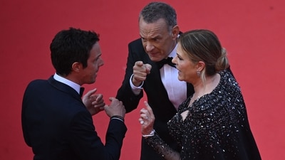 US actor Tom Hanks (C) and US actress Rita Wilson argue with a staff member as they arrive for the screening of the film "Asteroid City" during the 76th edition of the Cannes Film Festival in Cannes, southern France, on May 23, 2023. (AFP)