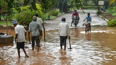 People wade through a waterlogged road after a rain shower in Bengaluru. (AFP/Image for representation) People wade through a waterlogged road after a rain shower in Bengaluru. (AFP/Image for representation)