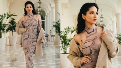 Sunny Leone poses in a printed dress and tan jacket at the Cannes Film Festival. Sunny Leone poses in a printed dress and tan jacket at the Cannes Film Festival.