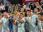Inter Milan's Argentinian forward Lautaro Martinez (C) and his teammates celebrate with the trophy after winning the Italian Cup (Coppa Italia) final football match between Fiorentina and Inter Milan at the Stadio Olimpico in Rome