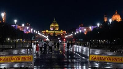 People walk during rains at Kartavya Path, in New Delhi on Thursday. (PTI)