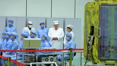 North Korean leader Kim Jong Un (top, 2nd R) and his daughter, presumed to be named Ju Ae (top, R), meeting with the Non-permanent Satellite Launch Preparatory Committee and inspecting a military reconnaissance satellite, at an undisclosed location in North Korea. (AFP)