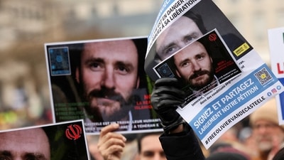People hold pictures of Belgian aid worker Olivier Vandecasteele during a protest against his detention in Iran, as he was sentenced to 40 years in prison and 74 lashes on charges including spying, in Brussels, Belgium. (REUTERS)