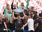 Thomas Mueller celebrates with the trophy and teammates after winning the Bundesliga