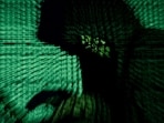 FILE PHOTO: A man holds a laptop computer as cyber code is projected on him in this illustration picture taken on May 13, 2017. REUTERS/Kacper Pempel//File Photo