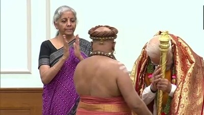 A priest hands over Sengol to Prime Minister Narendra Modi at his official residence.