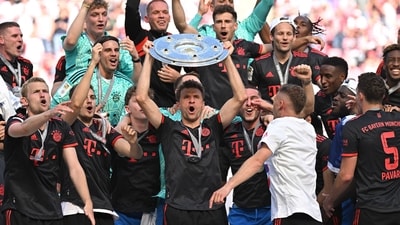 Thomas Mueller celebrates with the trophy and teammates after winning the Bundesliga (REUTERS)