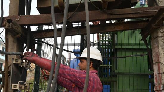 Gurugram, India-May 25 : A DHBVN worker repairing the damaged wire due to overload on a hot summer day at 4/8 Marla Near Government School, in Gurugram, India, on Thursday, 25 May 2023. (Photo by Parveen Kumar/Hindustan Times)(Pic to go with Leena Dhankar's story)