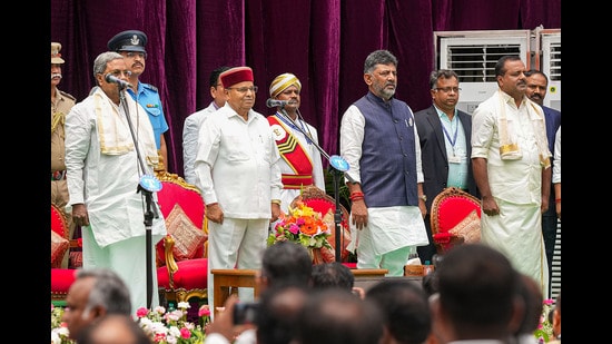 Karnataka Governor Thaawarchand Gehlot, chief minister Siddaramaiah and deputy chief minister DK Shivakumar with newly-inducted cabinet ministers during the swearing-in ceremony at Raj Bhavan, in Bengaluru on Saturday. (PTI)
