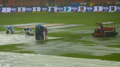 Groundsmen holding umbrellas near the covered pitch as it rains ahead of the IPL 2023 final cricket match between Gujarat Titans and Mumbai Indians (PTI) Groundsmen holding umbrellas near the covered pitch as it rains ahead of the IPL 2023 final cricket match between Gujarat Titans and Mumbai Indians (PTI)