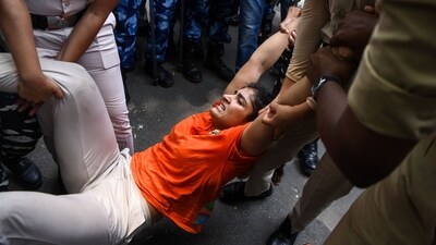 Police personnel drag wrestler Sangeeta Phogat to detain her during the protest march from Jantar Mantar to New Parliament House. (ANI) Police personnel drag wrestler Sangeeta Phogat to detain her during the protest march from Jantar Mantar to New Parliament House. (ANI)