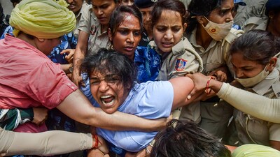Security personnel detain wrestler Sakshi Malik during wrestlers' protest march towards new Parliament building, in New Delhi, Sunday, May 28, 2023. (PTI) Security personnel detain wrestler Sakshi Malik during wrestlers' protest march towards new Parliament building, in New Delhi, Sunday, May 28, 2023. (PTI)