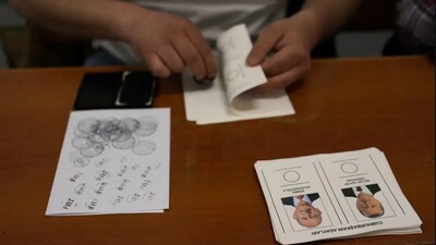 An election representative checks a stamp at a polling station in Istanbul, Turkey. (AP) An election representative checks a stamp at a polling station in Istanbul, Turkey. (AP)