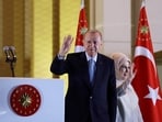 Turkish President Tayyip Erdogan and his wife Ermine Erdogan wave as he addresses his supporters following his victory. 