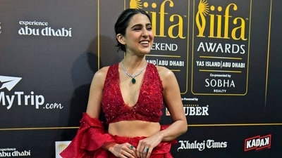 Sara Ali Khan flaunts her gorgeous &nbsp;red ensemble as she poses for the paparazzi with a smile. (AP)