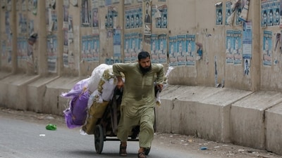 A labourer pulls a cart loaded with supplies to deliver to a nearby market in Karachi, Pakistan May 24, 2023. REUTERS/Akhtar Soomro