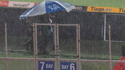 People walk under umbrellas as it rains heavily before the start of the IPL 2023 final (PTI) People walk under umbrellas as it rains heavily before the start of the IPL 2023 final (PTI)